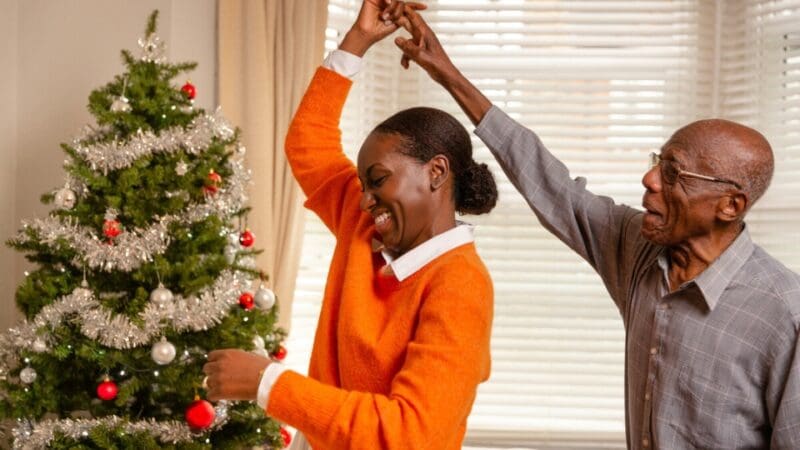 A man with dementia, supported by his daughter at home during Christmas time.